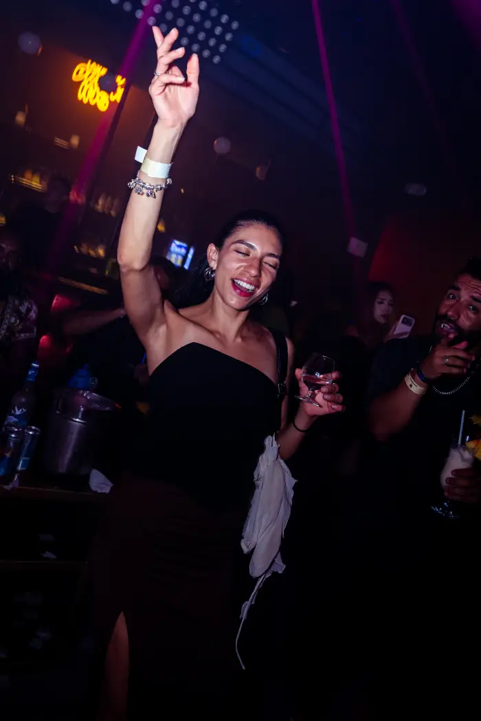 Partygoer dancing with a drink at Mandala Cancun